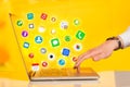 Hand pressing modern laptop with mobile app icons and symbols Royalty Free Stock Photo