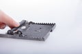 Hand pressing on a steel mouse trap in a white background