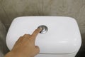 Hand is pressing the toilet flush button Royalty Free Stock Photo