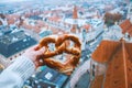 Hand with pretzel on the background of the panorama of Munich. Germany in winter.