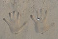 Hand prints with wedding bands on beach sand Royalty Free Stock Photo