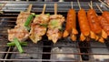 Hand process of cooking satay on grill