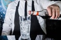 The hand of a professional bartender pours red syrup into a glass of ice cubes. The process of preparing an alcoholic cocktail Royalty Free Stock Photo