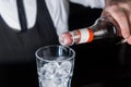 The hand of a professional bartender pours red syrup into a glass of ice cubes. The process of preparing an alcoholic cocktail Royalty Free Stock Photo