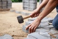 Hand of professional paver worker lays paving stones in layers for pathway Royalty Free Stock Photo