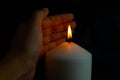 Hand protecting candle light from the wind in darkness Royalty Free Stock Photo