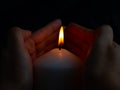 Hand protecting candle light from the wind in darkness Royalty Free Stock Photo
