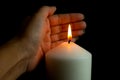 Hand protecting candle light from the wind in darkness Royalty Free Stock Photo