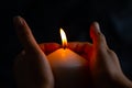 Hand protecting candle light from the wind in darkness Royalty Free Stock Photo