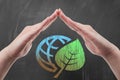 Hand protecting earth globe with green leaf draw on blackboard Royalty Free Stock Photo