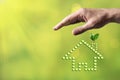 Hand protecting eco home made of drop water with small green sprout plant. Real Estate, insurance concept Royalty Free Stock Photo