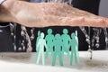 Hand Protecting Paper Cutout Human Figures From Water Royalty Free Stock Photo