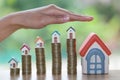 Hand protection, house model on top of stack of money as growth Royalty Free Stock Photo