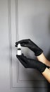 Hand in protective blue glove holding empty bottle. Small plastic container with cup. on grey background