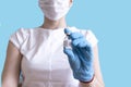 Hand in protective blue gloves hold medicine bottle of vaccine on blue background. Concept of vaccination and healthcare Royalty Free Stock Photo