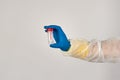 Hand in protective glove holding empty bottle for analysis.