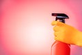 Hand in protective glove holding spray bottle. Royalty Free Stock Photo