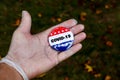 Hand with protective glove showing vote pin button with COVID-19 text