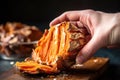 hand pulling apart halved baked sweet potato, revealing inner texture Royalty Free Stock Photo