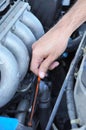 Hand pulling dipstick checking car engine oil Royalty Free Stock Photo