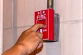 Hand pulling down the manual fire alarm station in case of fire emergency Royalty Free Stock Photo