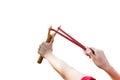 Hand pulling slingshot to shoot tree seed to forest. Royalty Free Stock Photo