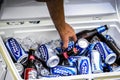 A hand pulls a beer from a cooler box Royalty Free Stock Photo