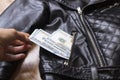 Hand pulls dollars out of jacket pocket Royalty Free Stock Photo