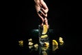 The hand pulls out a slice of lemon from a glass of water. Black background, reflection in the glass Royalty Free Stock Photo