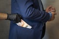 hand pulls paper money out of his jacket pocket. A thief robbed a businessman. Cash theft, criminal concept.