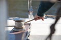 Hand pulls the rope around winch of sailboat closeup Royalty Free Stock Photo