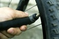 Hand pump. guy shakes a flat tire from a mountain bike. bicycle wheel Royalty Free Stock Photo