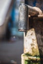 Hand pump to pull under ground water in india. Using Manual Water Pump on street. Water leaking from hand water pump in india. Royalty Free Stock Photo