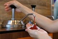 Hand pumping ketchup from sauce pump in to small plastic bowl in fast food restaurant