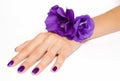 Hand with purple manicure and flowers