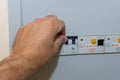 Hand pushes breaker in a fuse box in a residential house looking at the electrical breakers fixing loss of power Royalty Free Stock Photo