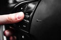 Hand pushes cruise control button on steering wheel and speed limitation. Royalty Free Stock Photo