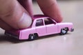 Hand pushing a pink toy car Royalty Free Stock Photo