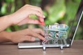 Hand pushing a shopping cart full of Australian dollar bills next to the laptop Royalty Free Stock Photo