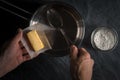 Hand put the butter in a bucket for making roux Royalty Free Stock Photo