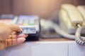 Hand put credit card In slot of credit card reader and telephone Royalty Free Stock Photo