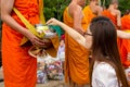 Hand while put food offerings in a Buddhist monk's alms bowl. f
