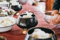 Hand while put food offerings in a Buddhist monk`s alms bowl.Sticky rice in alms bowl for buddhist monks Powder and sweet Coconut