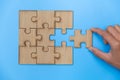 Hand put the last piece of jigsaw puzzle on  blue background to complete the mission,   Team business concept Royalty Free Stock Photo