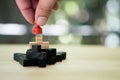 Hand put a red chess pawn on wooden puzzle Royalty Free Stock Photo