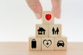 Hand put wooden block with security on top of pyramid shape on wood table for property, personal, family, travel and health Royalty Free Stock Photo