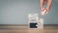 Hand put wooden cubes block with a big magnet to attract money.