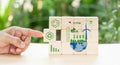 Hand put wooden cubes the symbols of circular economy on green background.Circular economy concept, recycle, environment, reuse, Royalty Free Stock Photo