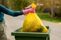 hand put plastic unsorted garbage bag into trash bin. household waste Royalty Free Stock Photo