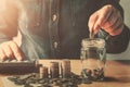 hand puting coins into jug glass for saving money finance and accounting
